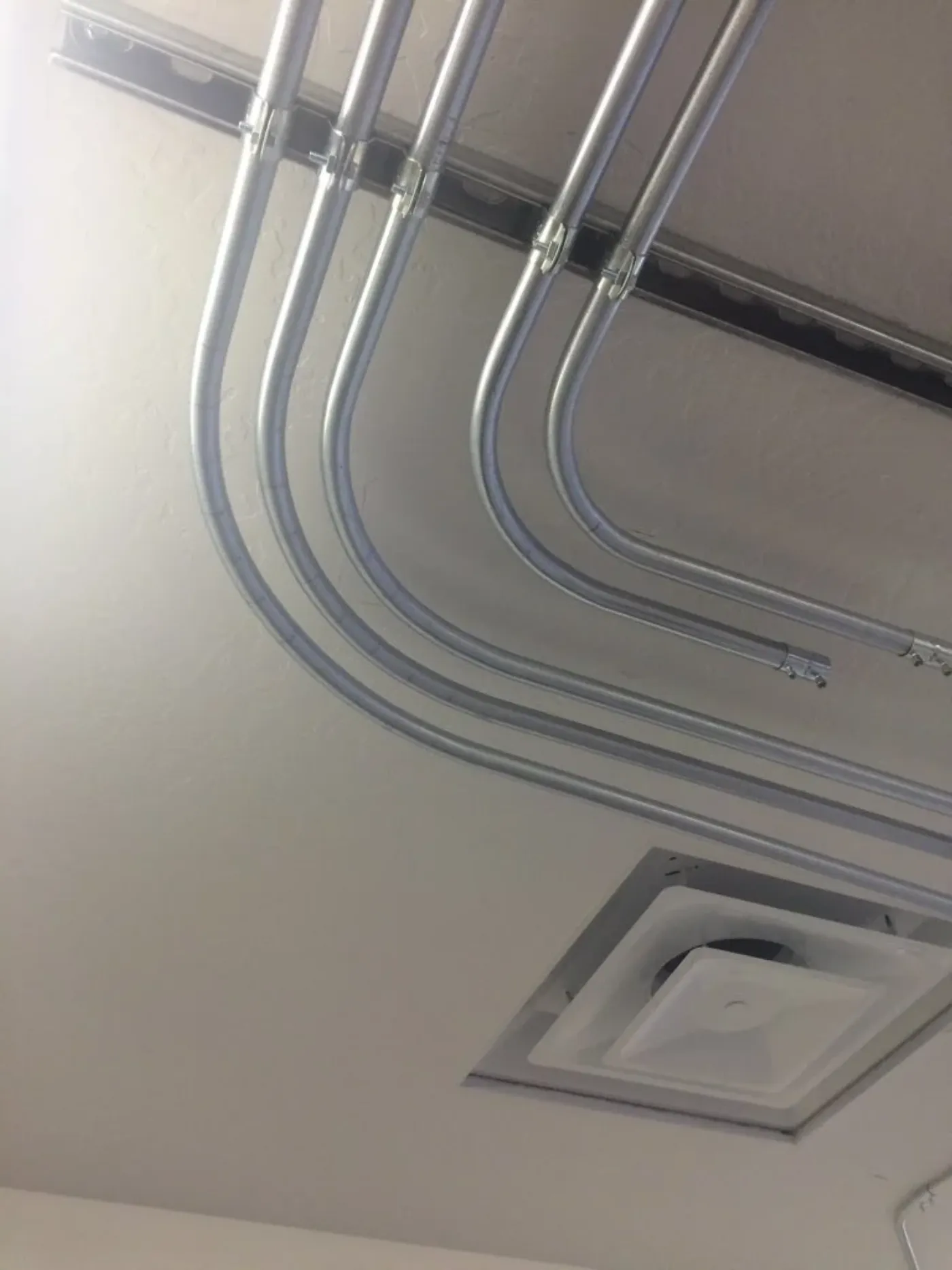 A run of concentric conduit bends kept parallel through a ninety-degree turn